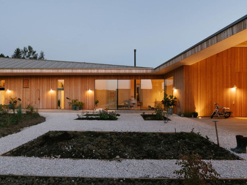 Haus mit Holzfassade und minimal windows bei Nacht 