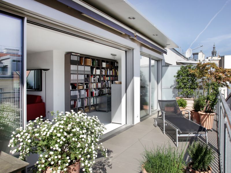 Sonnige Terrasse mit weit aufgeschobenen Schiebetüren aus Glas