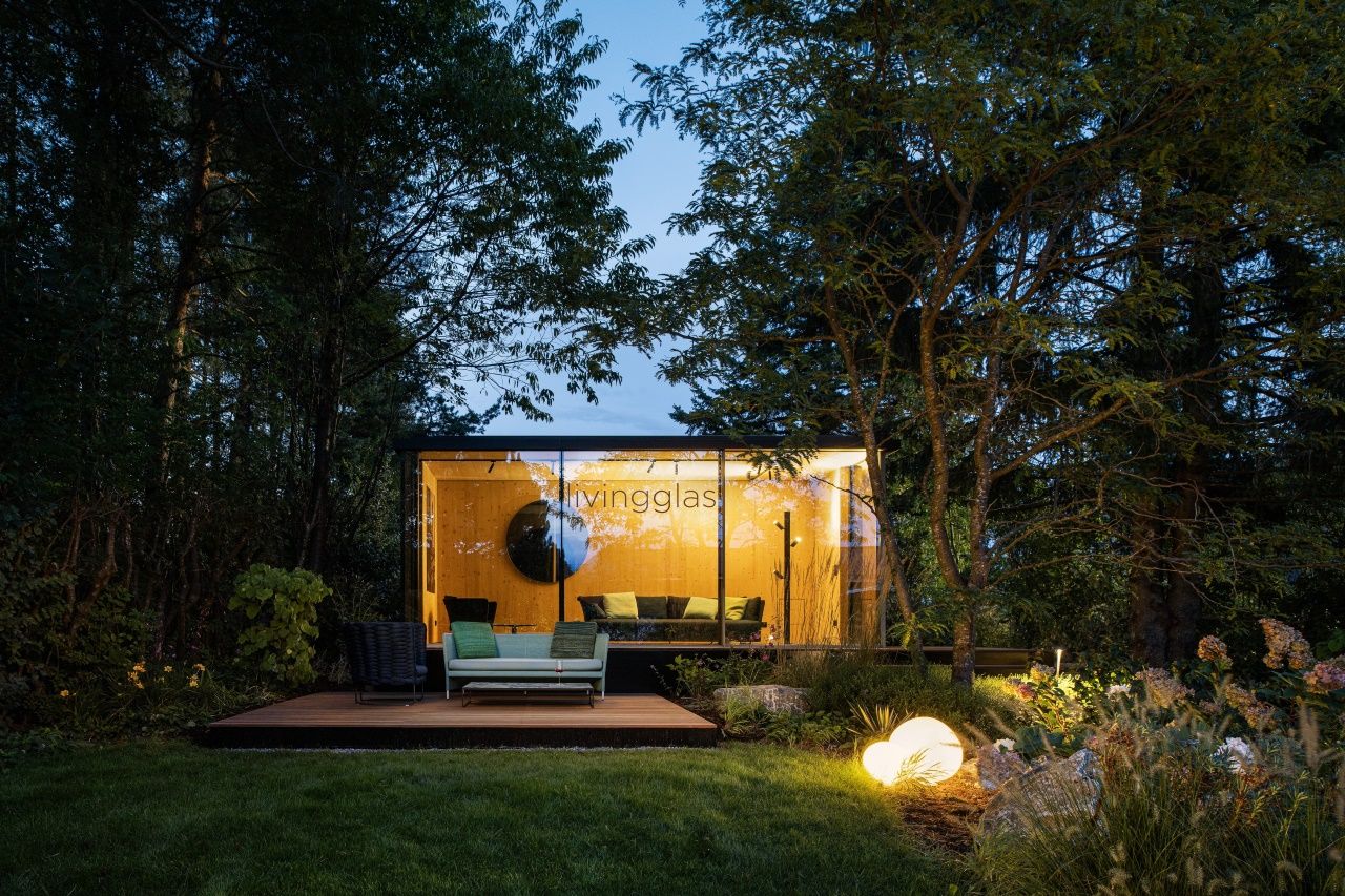 Gartenpavillon in der Nacht, beleuchtet mit rahmenlosen Schiebetüren